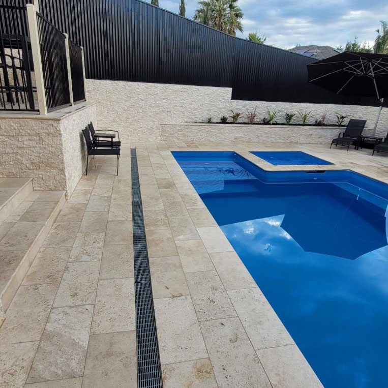 Classic Cream Travertine pool paving and Bookleaf Wall Cladding2
